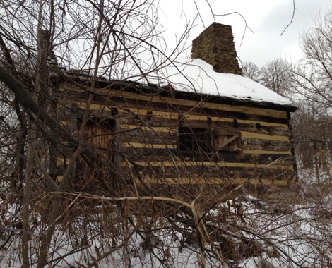 The Neill Log House, photographed through a fence
